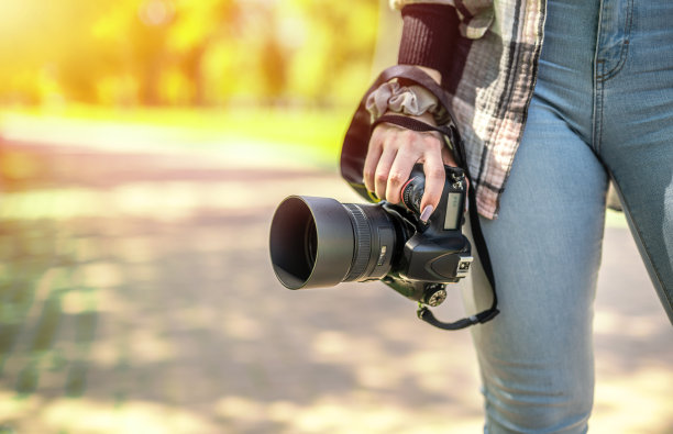 手持相机的自由职业女性摄影师。创造性的职业理念图片下载