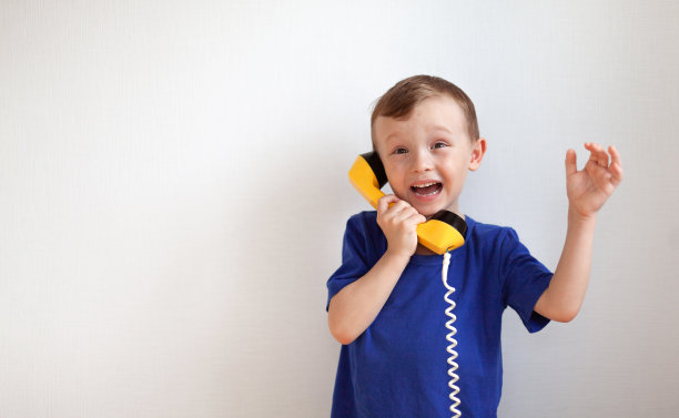 一个穿蓝色t恤的四岁男孩正骑着黄色的ret说话图片下载