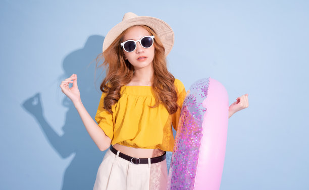 年轻的亚洲女孩肖像在蓝色背景，暑假的概念图片下载