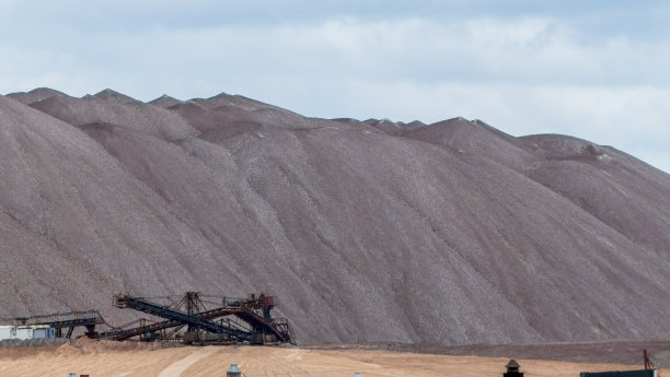 在多云的天空背景下开采钾矿时的空矿山。把一块空石头运到垃圾场。图片下载