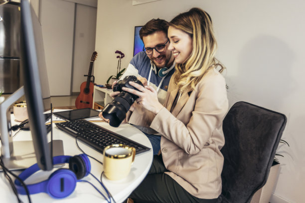 两个年轻的摄影师在办公室工作图片下载