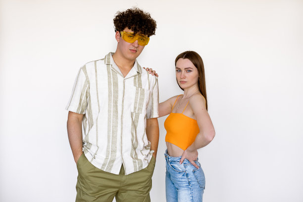 时尚夫妇摆姿势，穿着季节性的服装和配件的男人和女人，白色背景。魅力时尚风格目录为年轻人休闲装，春夏流行趋势图片下载