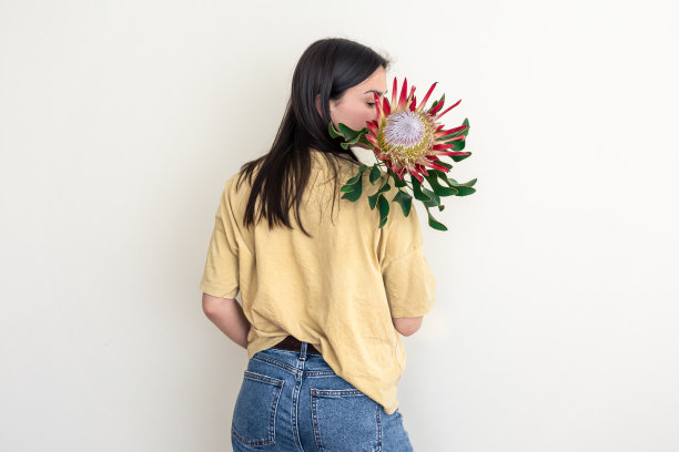 一个年轻的女人，在白色的背景上画着普罗塔花。图片下载