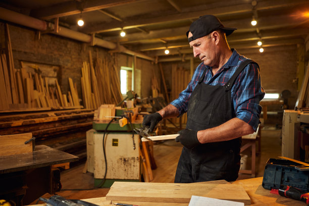 在木工车间使用卡钳工作的资深专业木匠图片下载