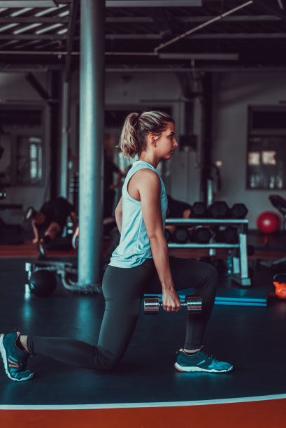 迷人的女人工作，在健身房举重，股票照片图片下载