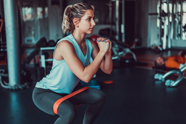 有魅力的女人在健身房用橡皮筋锻炼，库存照片图片下载