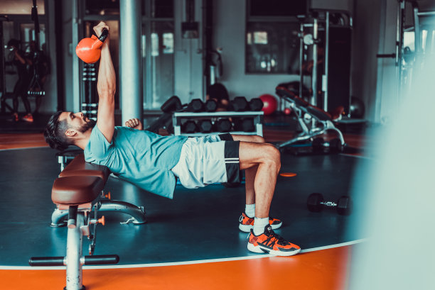 帅哥在健身房举重，股票照片图片下载