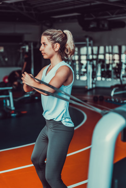 有魅力的女人用橡皮筋在健身房锻炼，库存照片图片下载
