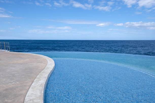 室外游泳池碧蓝清澈的水面，海景，地平线。暑假和休息的概念。波纹在水面上。水池底部的花纹由波纹状的马赛克瓷砖制成图片下载