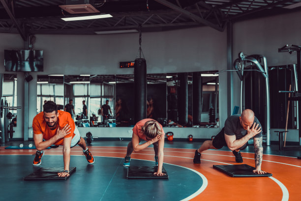 三个肌肉发达和有吸引力的运动员在健身房锻炼和伸展，股票照片图片下载