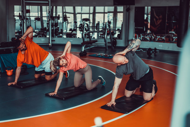 三个肌肉发达和有吸引力的运动员在健身房锻炼和伸展，股票照片图片下载
