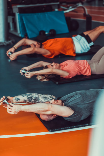 三个肌肉发达和有吸引力的运动员在健身房锻炼和伸展，股票照片图片下载