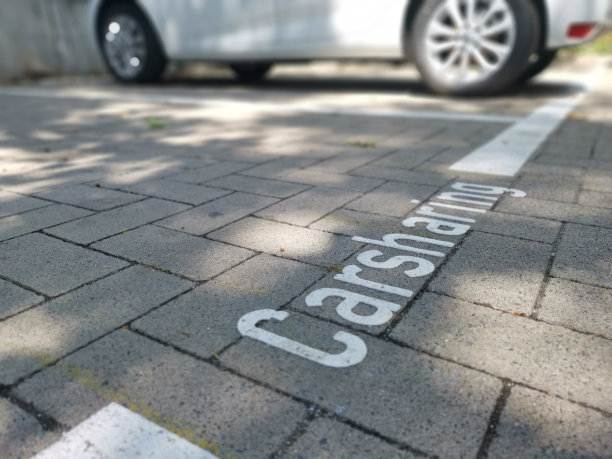 铭文汽车共享在地面上和汽车的一部分失焦在背景图片下载