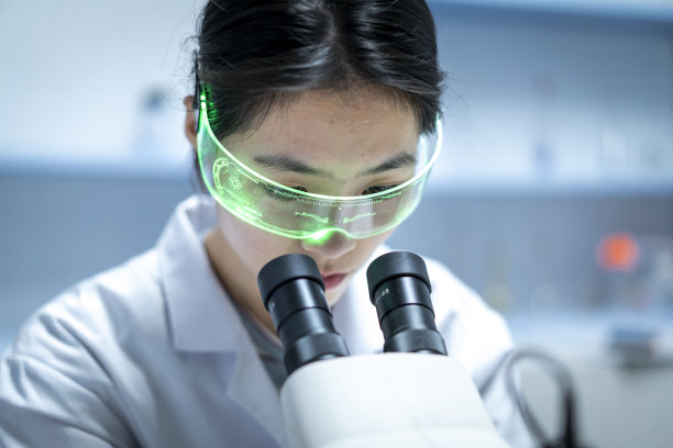 一位年轻的亚洲女科学家在看显微镜图片下载