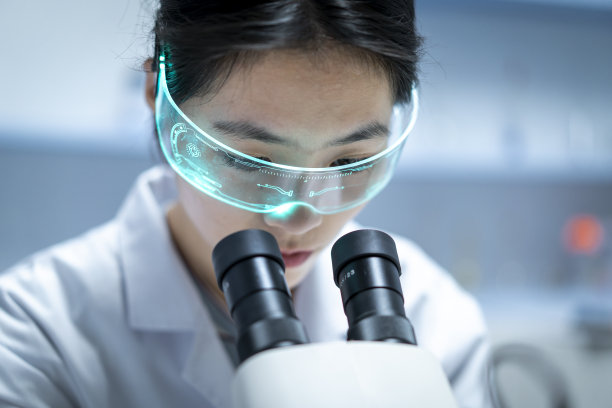 一位年轻的亚洲女科学家在看显微镜图片下载