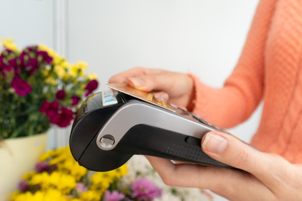 近距离的支付终端手中的花店与客户的手支付订单使用非接触式卡图片下载