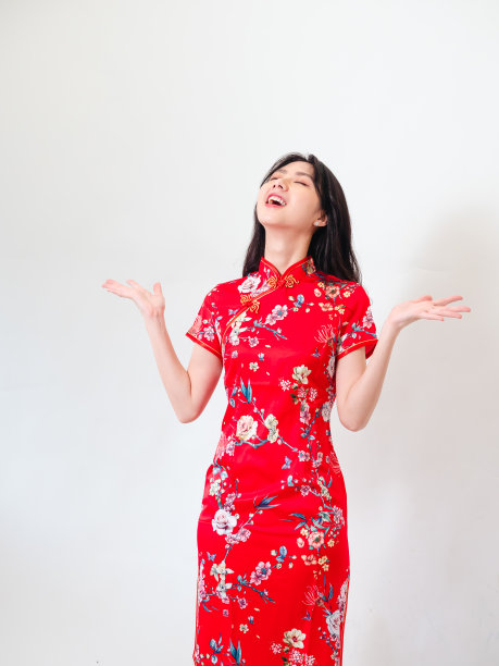 年轻的亚洲妇女的肖像穿着传统旗袍旗袍礼服在孤立的白色背景持有copyspace与双手。图片下载