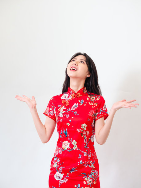 年轻的亚洲妇女的肖像穿着传统旗袍旗袍礼服在孤立的白色背景持有copyspace与双手。图片下载