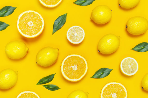 成熟多汁的柠檬和绿色的叶子在明亮的黄色背景。柠檬水果，柑橘的简约概念，维生素c的创意夏季食物的简约背景。平面布局，俯视图，拷贝空间图片下载