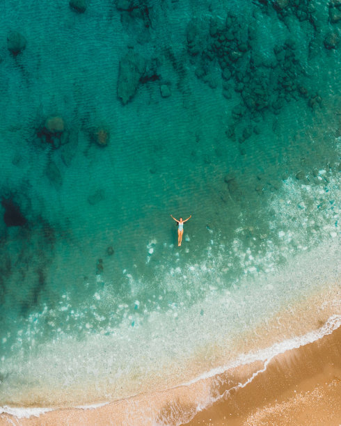 一名女子漂浮在水晶蓝色的海洋与珊瑚礁在土耳其的鸟瞰图图片下载