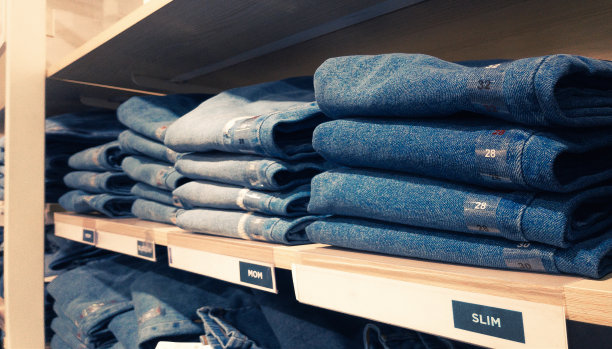 木制货架上摆放着各种各样的蓝色牛仔裤图片下载