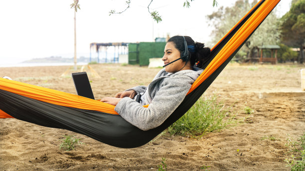 度假的白领女性，在吊床上用笔记本电脑工作图片下载