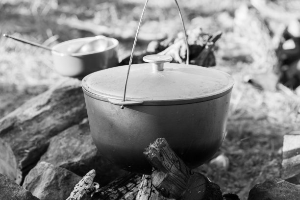 在火上准备一顿饭。篝火和大锅，黑白特写图片下载