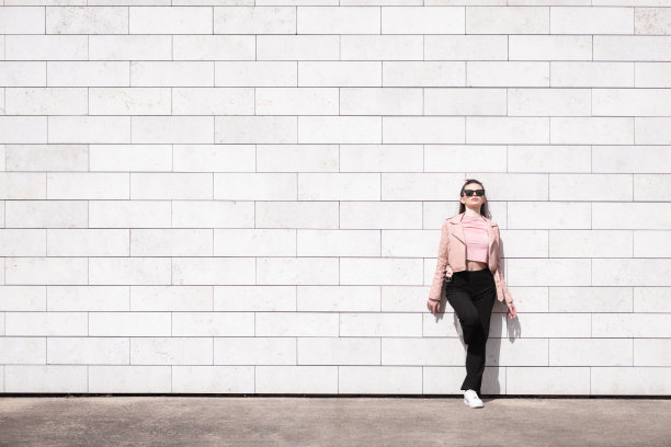 美丽的女人站在砖墙背景图片下载