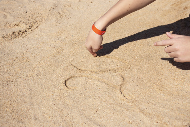 夏天男孩在海边的沙滩上画画图片下载