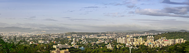 清晨的全景图，快速发展的城市有许多高楼大厦和漂亮的蓝天背景。图片下载