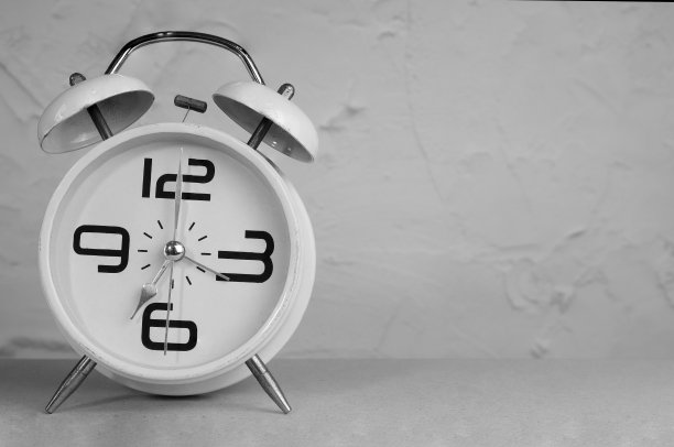 白色金属闹钟与两个铃声在黑白色调与复制空间。白色古董闹钟。时间概念图片下载