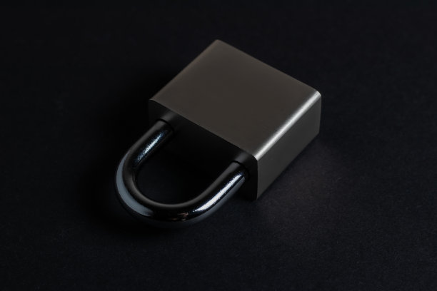 黑色纹理背景上的钢挂锁图片下载