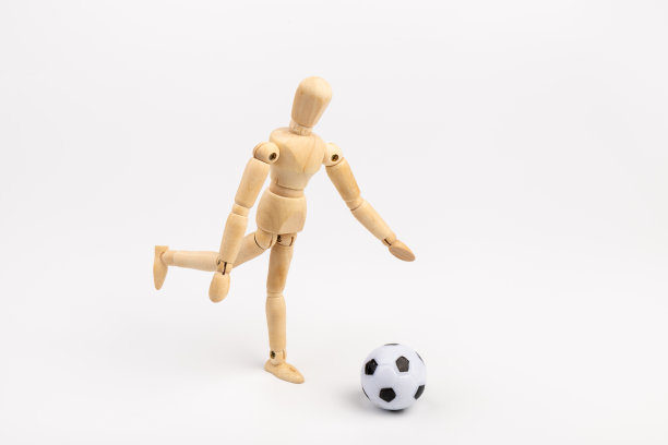木制假人与足球孤立在白色背景。足球运动员的概念。图片下载