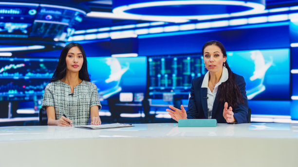 电视现场新闻节目:两位主持人报道，讨论日常事件，讨论商业，经济，科学，娱乐。有线电视频道多样化主播谈话。播放新闻编辑室工作室图片下载