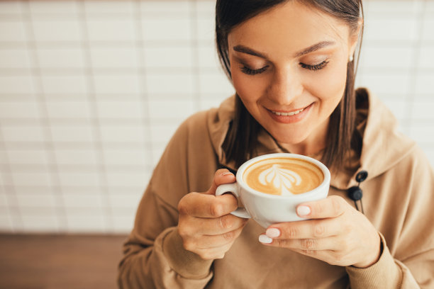 年轻女子坐在舒适的咖啡馆里喝着卡布奇诺。图片下载