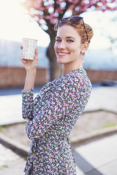 年轻新鲜的红发女人拿着塑料咖啡杯在户外图片下载