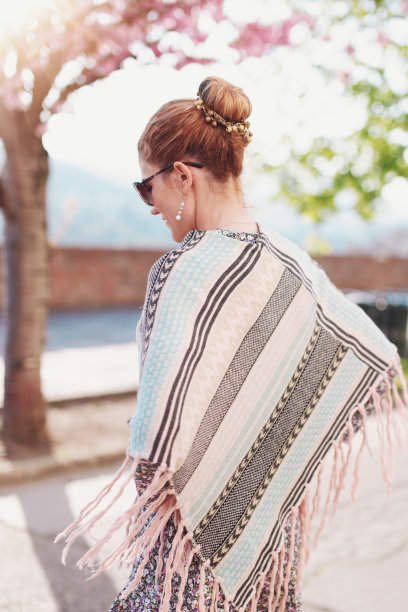 春天公园里穿着斗篷的年轻女子图片下载