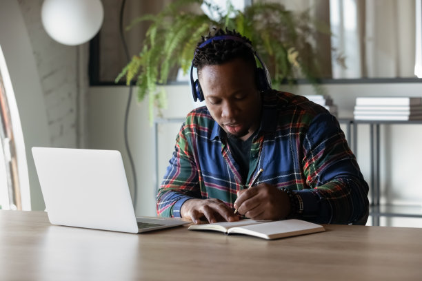 专注认真的非裔美国学生戴着耳机看网络研讨会图片下载
