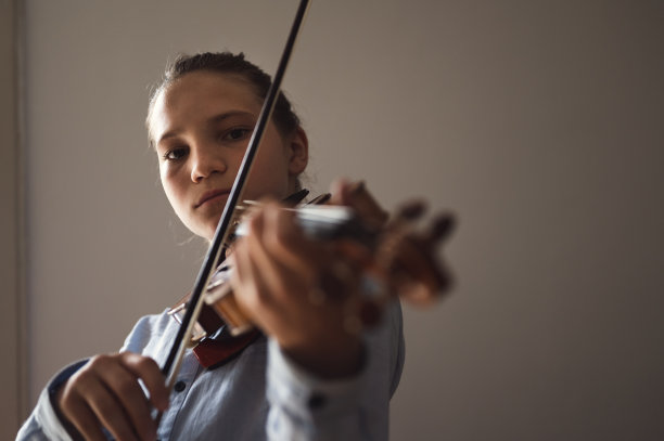 十几岁的孩子在室内拉小提琴图片下载