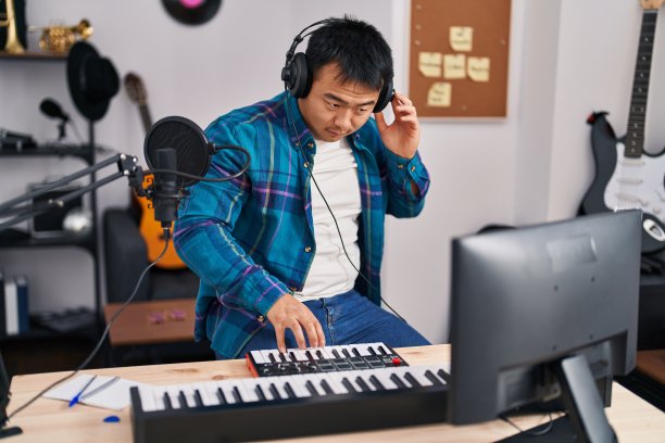 年轻的中国男子歌手唱歌，在音乐工作室弹奏钢琴键盘图片下载