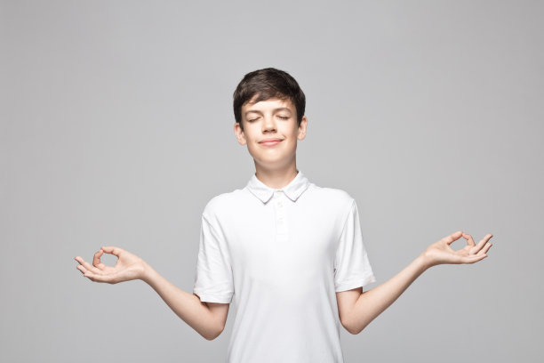 一个少年在灰色背景下冥想图片下载