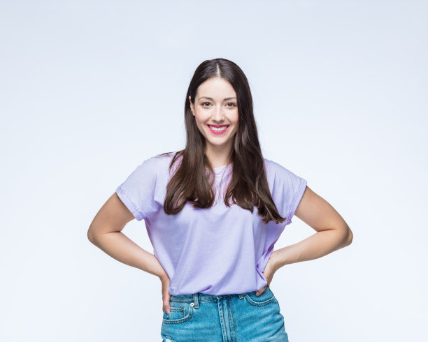 年轻女子微笑，手放在臀部图片下载