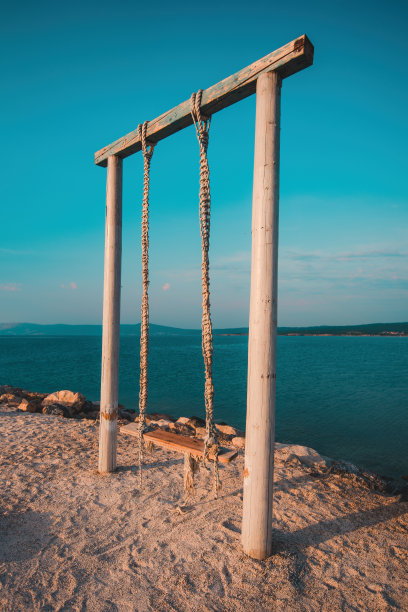 夏天的早晨，在海边的海滩秋千图片下载