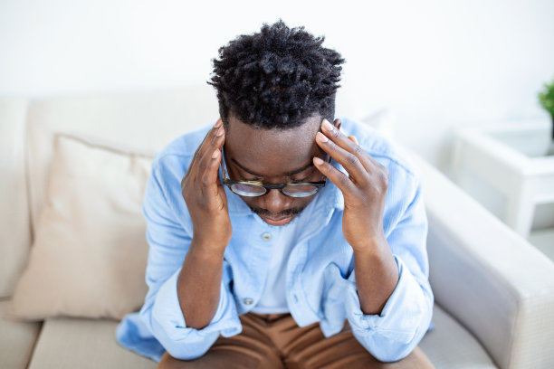 疲倦的非洲裔美国人摘下眼镜，精疲力竭地按摩鼻梁，长时间在电脑工作后眼睛疲劳，感觉疼痛，健康问题概念图片下载