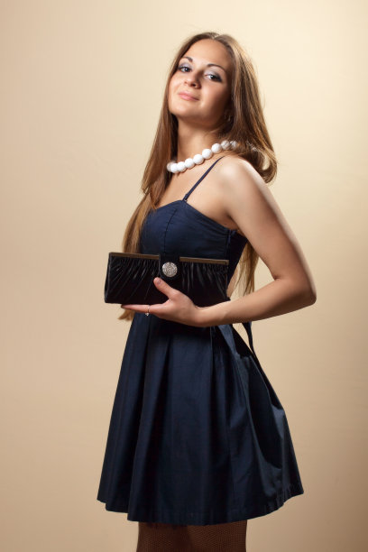 时髦的年轻女子，手里拿着黑色手包图片下载