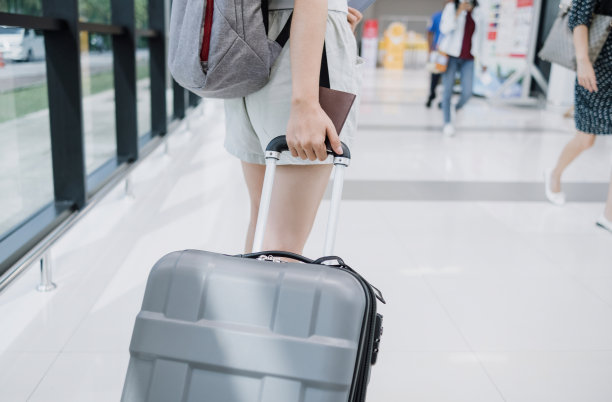 在机场拖着行李的亚洲女游客。图片下载