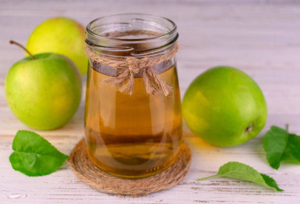 白色背景下玻璃瓶中的苹果汁。特写。图片下载