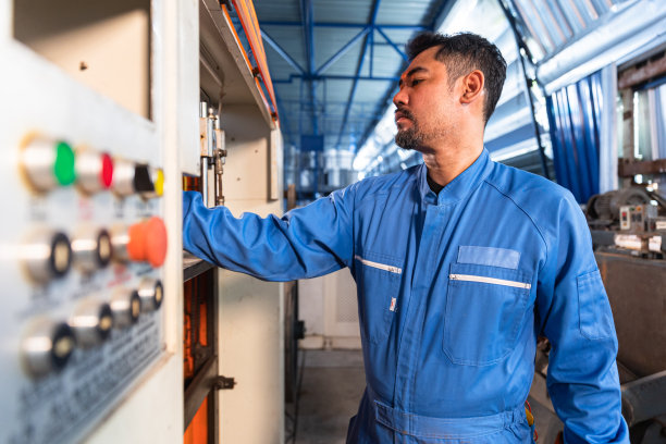 高级亚洲工程师，穿着防护服的工人，在工厂工业操作机器。在工业中进行团队合作。图片下载