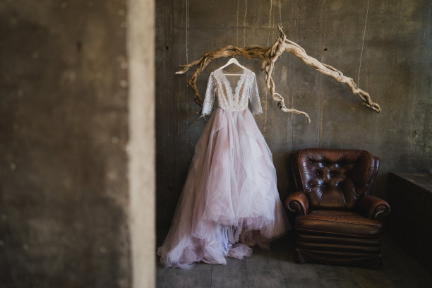 紫色的婚纱挂在混凝土阁楼内部的复古树枝上。图片下载