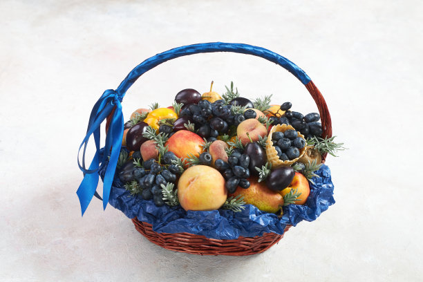 篮子装满了葡萄和其他水果在灰色的背景图片下载